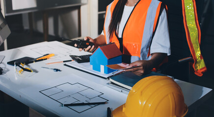 Closeup of team of industrial engineers meeting analyze machinery blueprints consult project on table in manufacturing factory. Working in manufacturing plant or production plant.