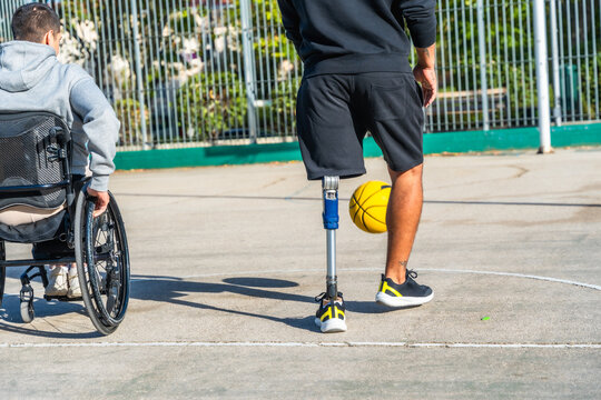 Disabled friends playing basketball with prosthetic leg and wheelchair - Powered by Adobe