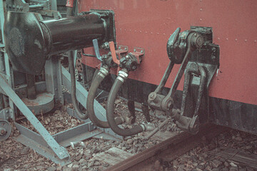 Detailed view of railway carriage coupling system with metal pipes and levers