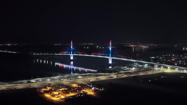 Panoramic nighttime aerial of illuminated Heroes of Chaco Bridge over Paraguay River in Asuncion