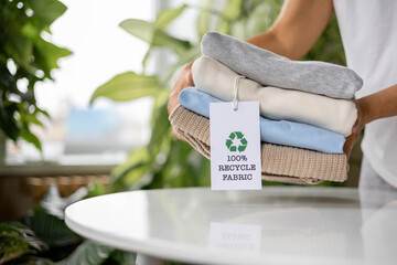 Sustainable fashion concept with folded eco-friendly clothes and recycling tag