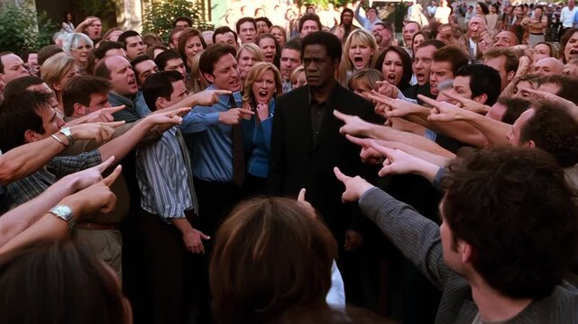 African American Man in the center surrounded by a crowd of people pointing fingers and shouting at him. Concept of blame and accusation, racial discrimination.