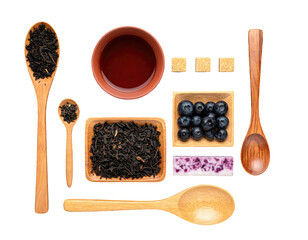 Flat lay arrangement of tea, blueberries, sugar, and wooden utensils