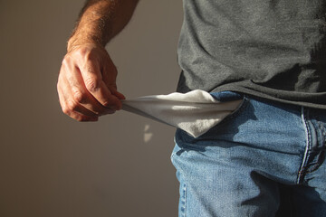 Caucasian man showing empty pocket. No money