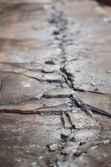 Cracked Concrete Surface with Broken Pieces Displaying Signs of Wear and Tear, Abstract Texture and Background for Construction and Urban Themes