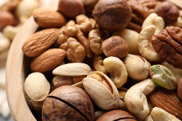 Mix of different nuts in bowl on table, closeup