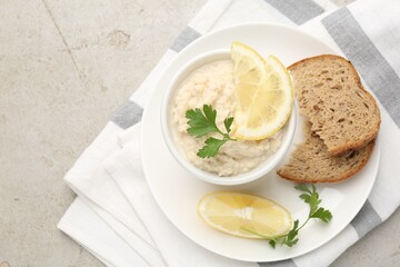 Tasty horseradish sauce with parsley and lemon slices served on light table, top view. Space for text