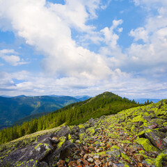 green mountain ridge under a blue cloudy sky