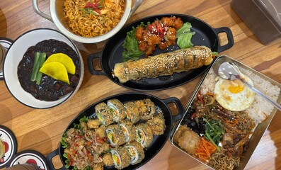 A set of Korean food consist of kimbap, dosirak rice box, jjajangmyeon, and spicy Korean noodle