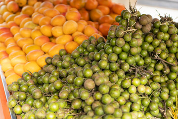 Tropical jocote fruit and mangoes at market stall