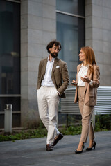 Businesspeople walking and talking outside office building