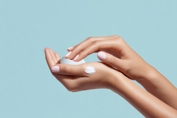 Hands applying cream on a bright blue background, embodying skincare, beauty, and the essence of self-care.