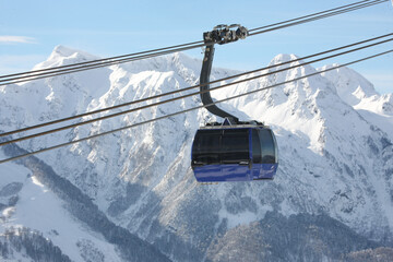 Gondola, cable car and ski lift with mountain, tree, blue sky on a sunny day at resort Krasnaya Polyana.