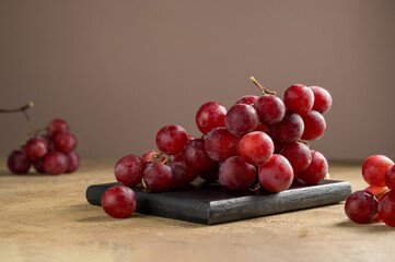 Pink grapes on brown neutral background, autumn harvest concept.