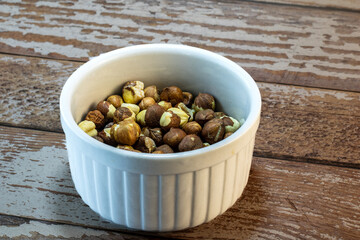 whole and cracked hazelnuts in bowl