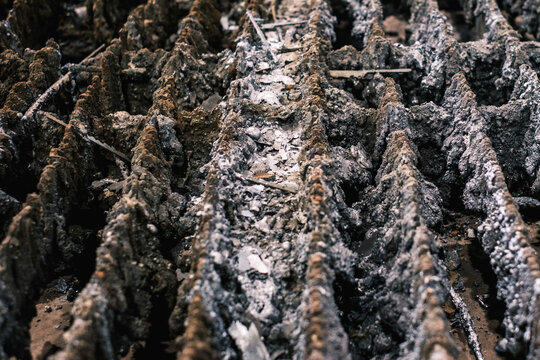 Industrial slag buildup under plasma cutting table, close-up of metal debris and molten residue from precision manufacturing process