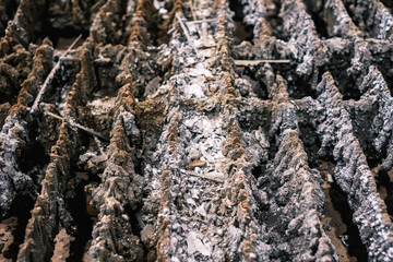 Close-up of slag-encrusted metal cutting table, worn industrial grate with hardened debris and residue from plasma or laser cutting process