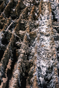 Close-up of worn plasma cutting table slats covered in slag and metal residue, gritty industrial workshop texture