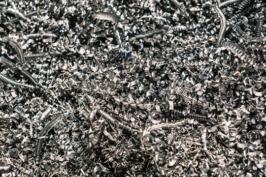 Close-up of metallic shavings and spirals, shiny steel scrap from industrial machining process used for recycling and metal production