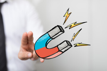 Hand reaching for a strong magnet, symbolizing business attraction, marketing, and lead generation.