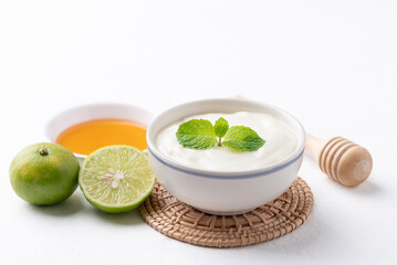 Yogurt, lime and honey on white background
