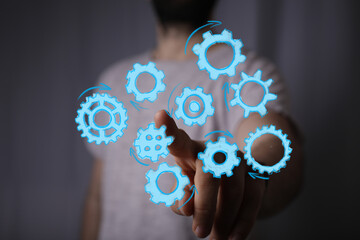 Abstract image of a man interacting with digital gears, symbolizing teamwork, process, workflow, and technology.