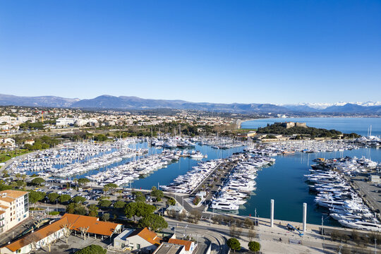 Aerial view of gleaming yachts nestled in the marina near the historic Fort Carr&Atilde;&copy; against the backdrop of the distant snow-capped Alps, Antibes, Provence-Alpes-C&Atilde;&acute;te d'Azur, France.