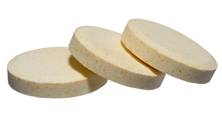 Stack of large round pills of light yellow color, isolated background