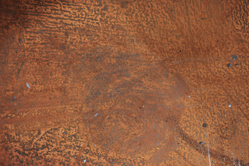 Weathered rusty metal sheet with textured corrosion and patina, close-up of oxidized industrial steel surface in earthy orange tones