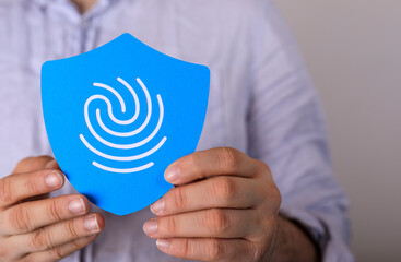 Image of hands holding a blue shield with a fingerprint, symbolizing data security and privacy.