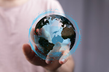 High-tech image of a hand holding a digital globe, representing global network, connection, and...