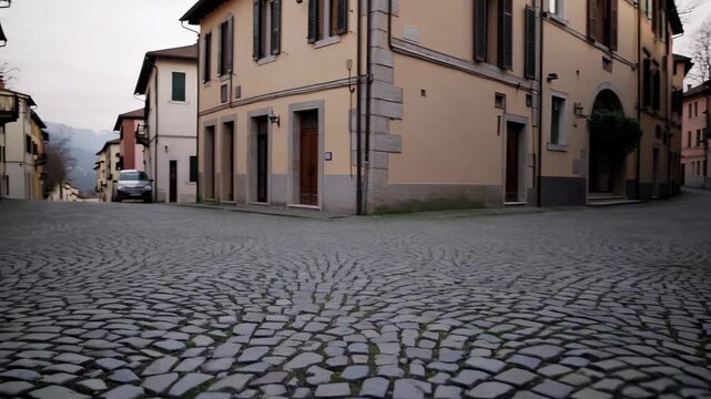The cobblestone street leads past buildings as the cobblestone interacts with the quiet urban environment. Yellow walls contrast with the cobblestone in the serene alleyway.
