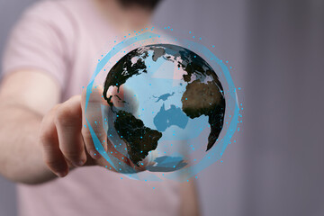 Person interacting with a digital globe, representing global network, technology, and connection.