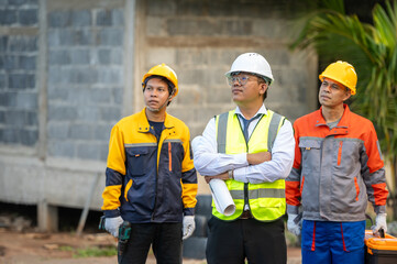 Construction Team's Insightful Planning: A trio of construction workers, equipped with safety gear and focused concentration, stand before the architectural skeleton of a building.