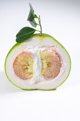 A Vertically Halved Pomelo with Leaves on a White Background