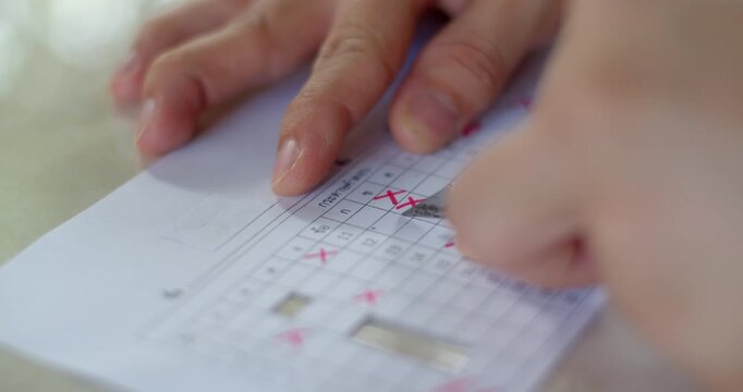 Cutting grid paper template for checking student answer sheets efficiently.Cutting answer sheets into grids for use as templates in checking multiple students&rsquo; exam papers.