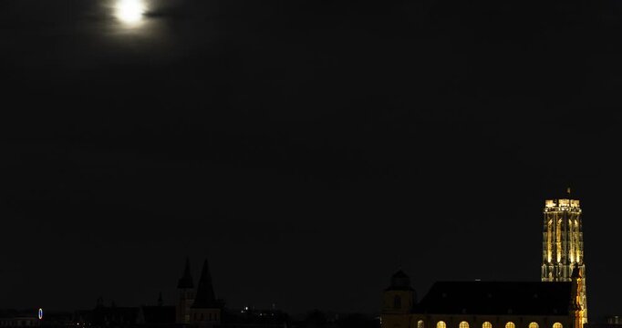 Glowing moon at night sky and St. Rumbold's Cathedral tower in Belgium, time lapse