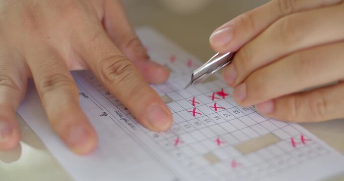 Cutting grid paper template for checking student answer sheets efficiently.Cutting answer sheets into grids for use as templates in checking multiple students&rsquo; exam papers.