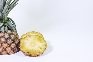 Whole Pineapple and Sliced Pieces on a White Background