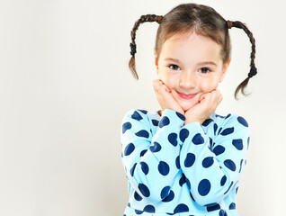 The child is a beautiful girl with wide eyes, look away in surprise. Baby in a knitted sweatshirt ....