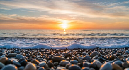 Gentle Ocean Waves Lap Against A Pebble Beach At Sunrise