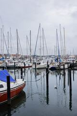 View of Flensburg harbor with numerous sailboats and colorful buildings