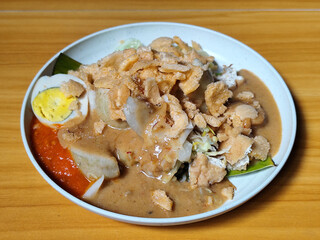 Gado Gado, traditional Indonesian vegetable salad with peanut sauce, chili sauce, lontong, tofu, cucumber, potatoes, and egg.