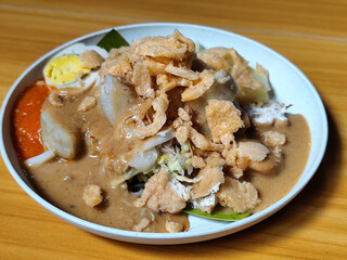 Gado Gado, traditional Indonesian vegetable salad with peanut sauce, chili sauce, lontong, tofu, cucumber, potatoes, and egg.