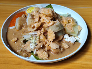 Gado Gado, traditional Indonesian vegetable salad with peanut sauce, chili sauce, lontong, tofu, cucumber, potatoes, and egg.