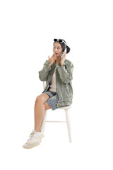 Intrigued young woman on the phone: A young woman is seated on a chair while on phone, embodying surprise or astonishment.