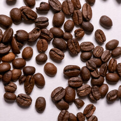 Roasted coffee beans scattered on white background macro closeup