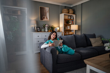 Naklejka premium Healthcare worker relaxing on sofa reading book