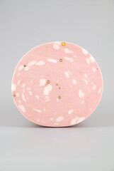 Sliced mortadella sausage on a white background