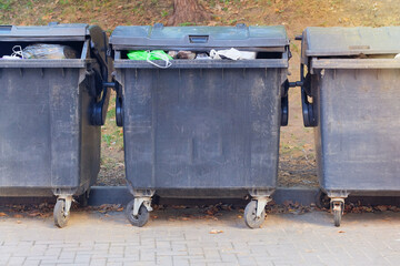 Dumpsters being full with garbage. Garbage, waste lots, junk dump. Trash cans.